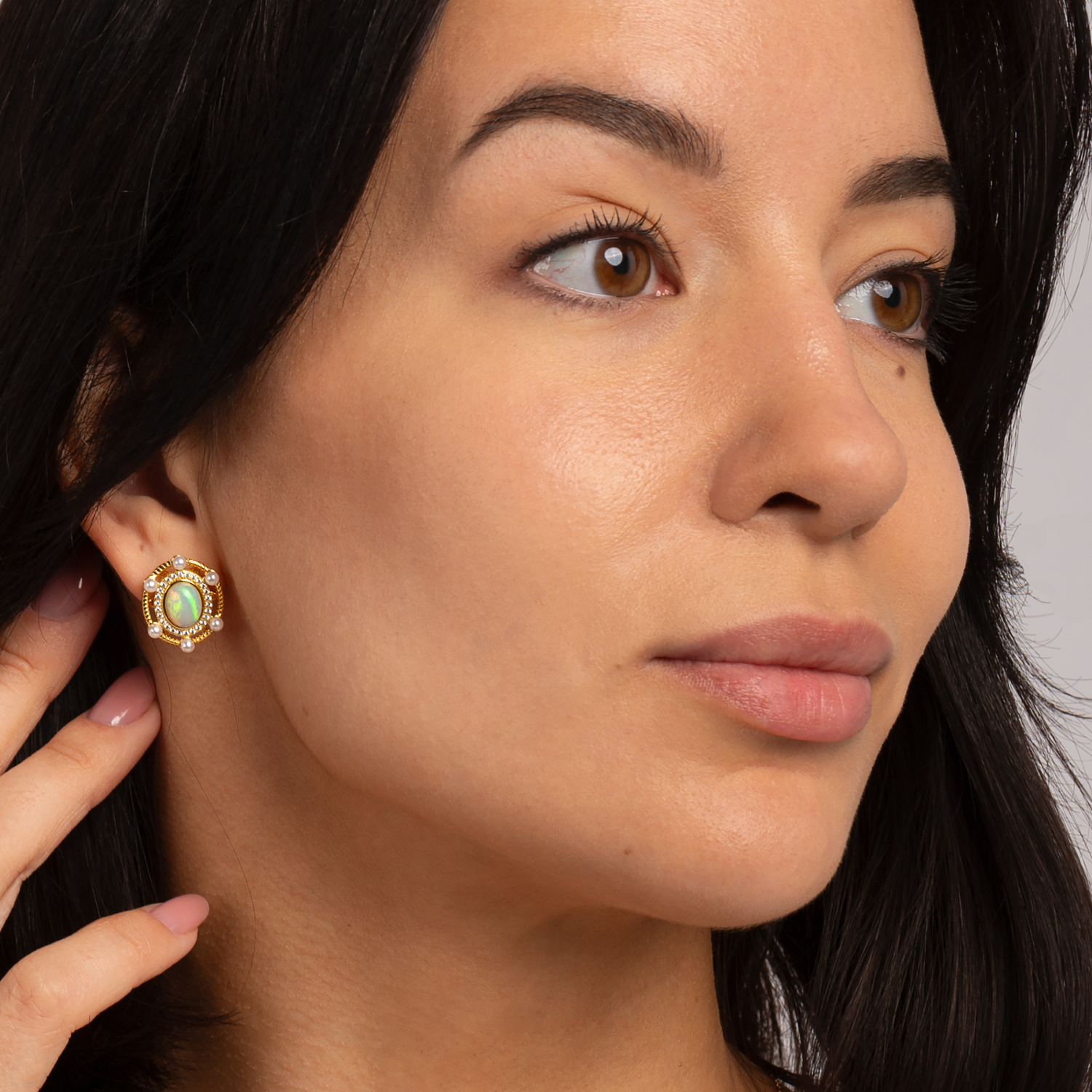 Model wearing 18k gold plated 925 sterling silver opal stud earrings surrounded by freshwater pearls and cubic zirconia