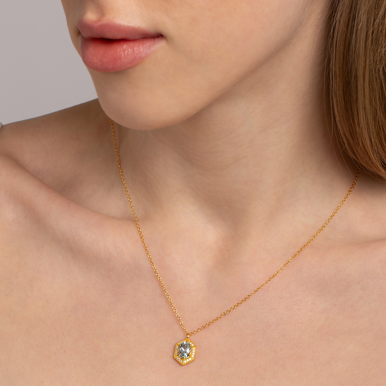 model wearing 18k gold plated 925 sterling silver blue topaz hexagon necklace
