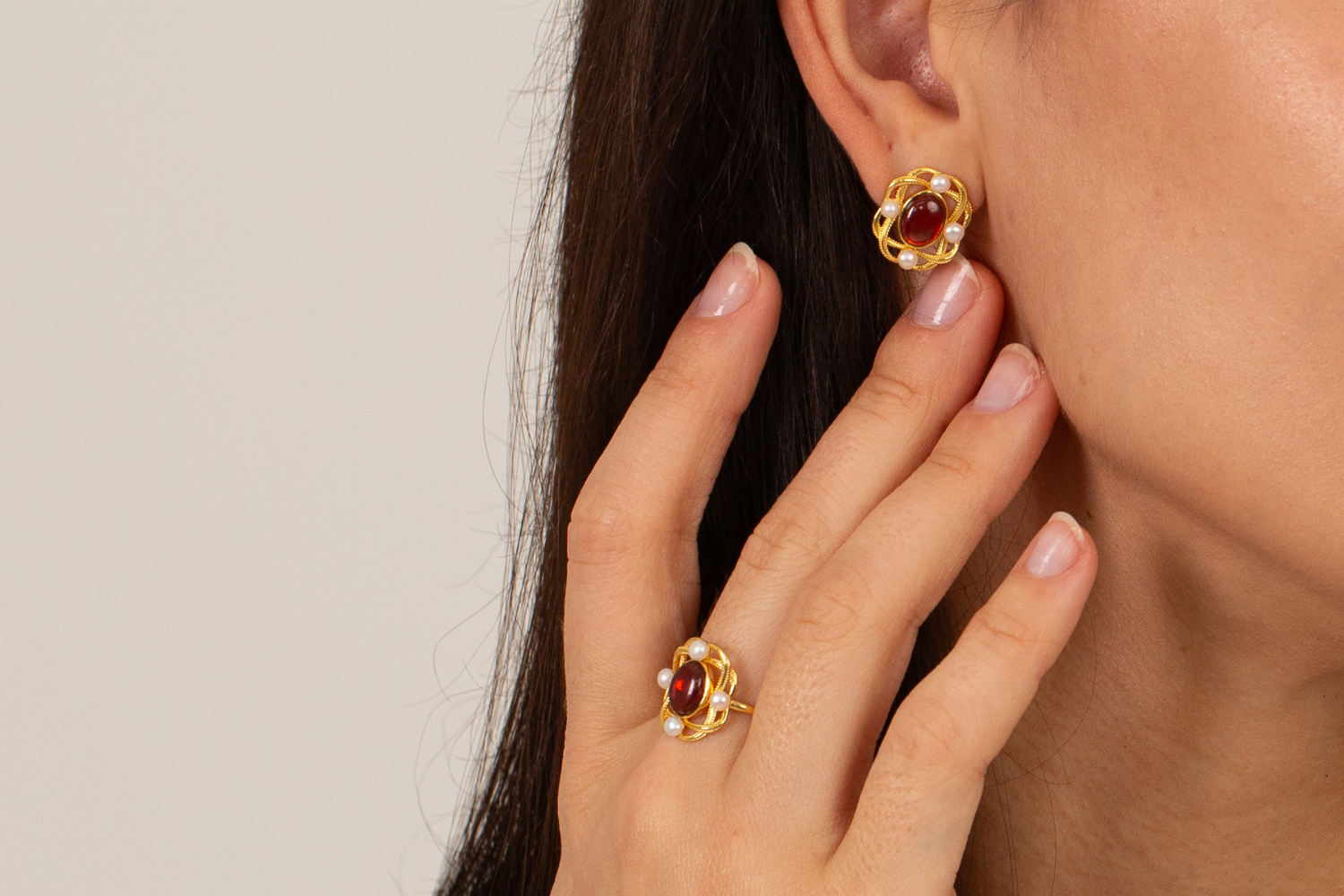 model wearing 18k gold plated sterling silver garnet pearl oval ring and earrings