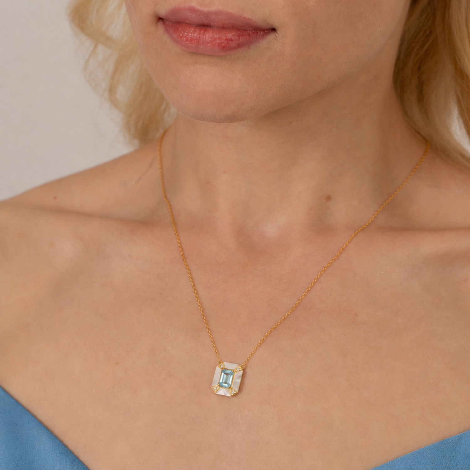 model wearing 18k gold plated sterling silver blue topaz pearl necklace