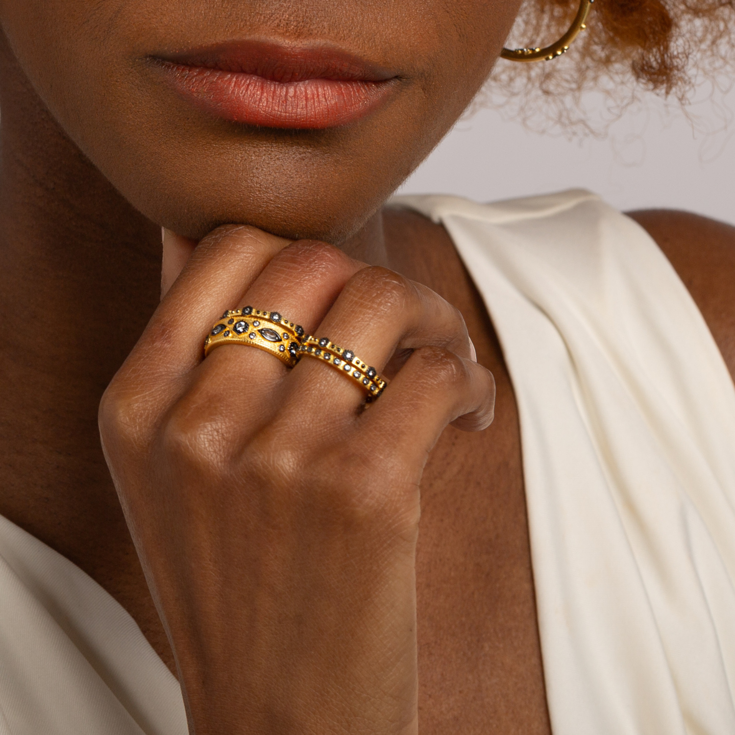 Model wearing 18k gold plated 925 sterling silver cubic zirconia dark rhodium detailing stacking ring. Design inspired by Greek Goddess Hera