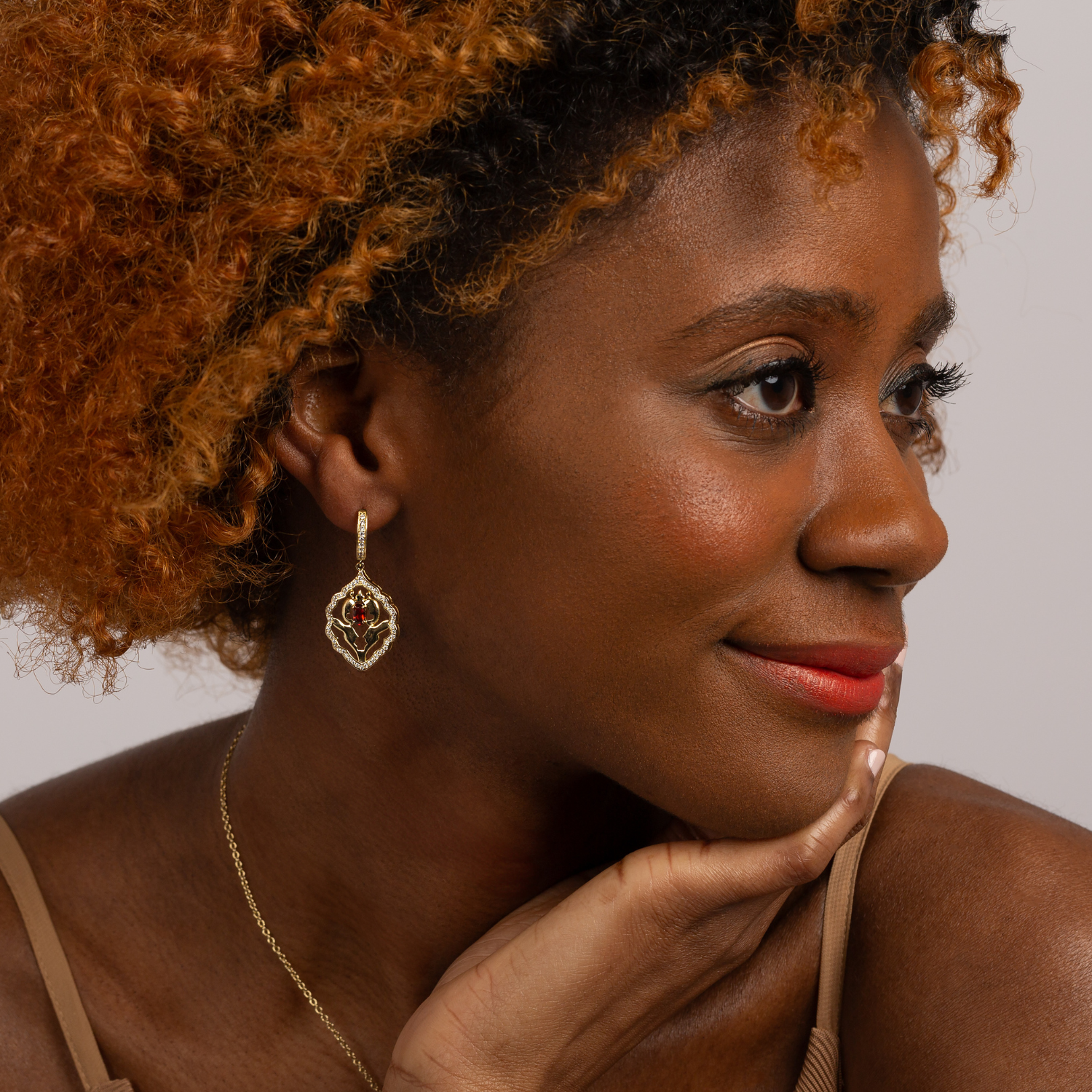 Model wearing a pair of 18k gold plated sterling silver garnet earrings with cubic zirconia accents