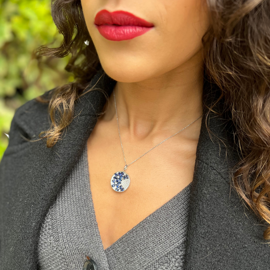 Model wearing Blossom Sapphire Necklace featuring floral pattern of Sapphire gemstones in 925 sterling silver