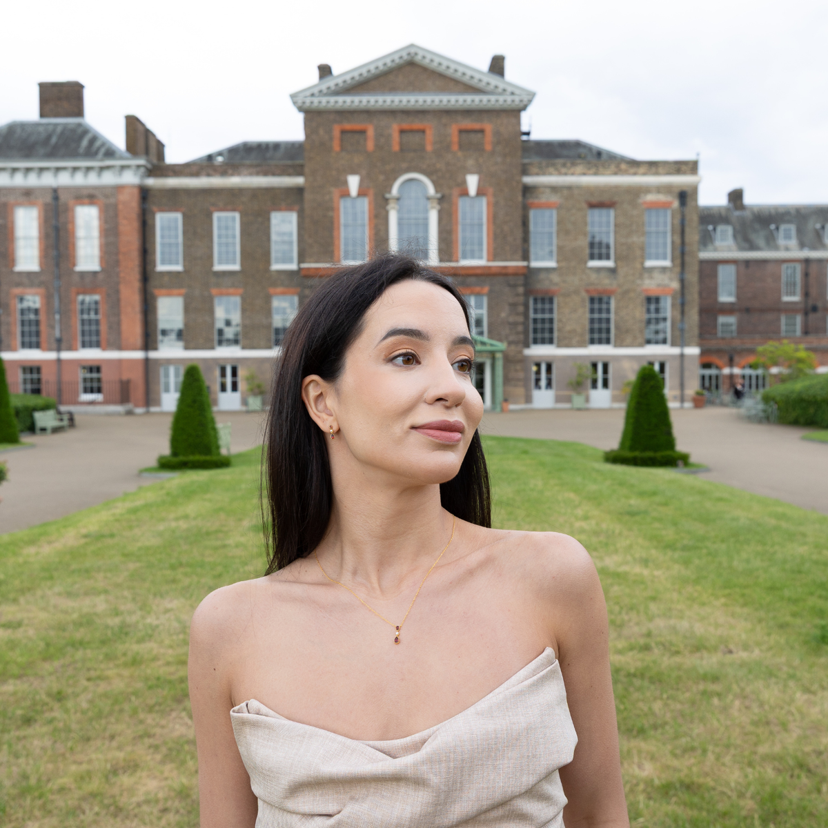 model wearing 18k gold plated sterling silver garnet tiara necklace outside kensington palace