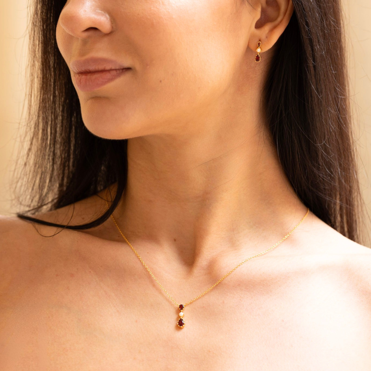 model wearing 18k gold plated sterling silver garnet tiara stud earrings