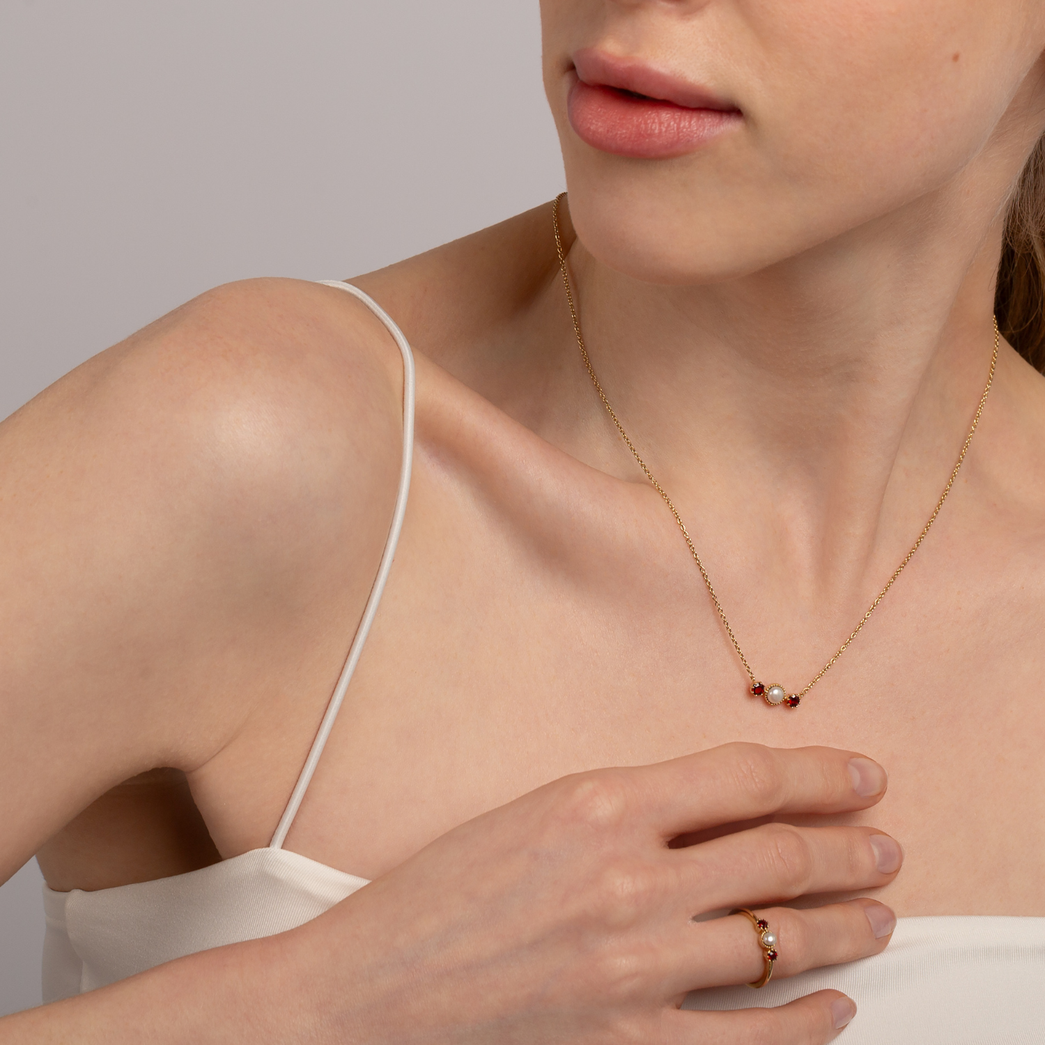 model wearing 18k gold 925 sterling silver pearl garnet ring