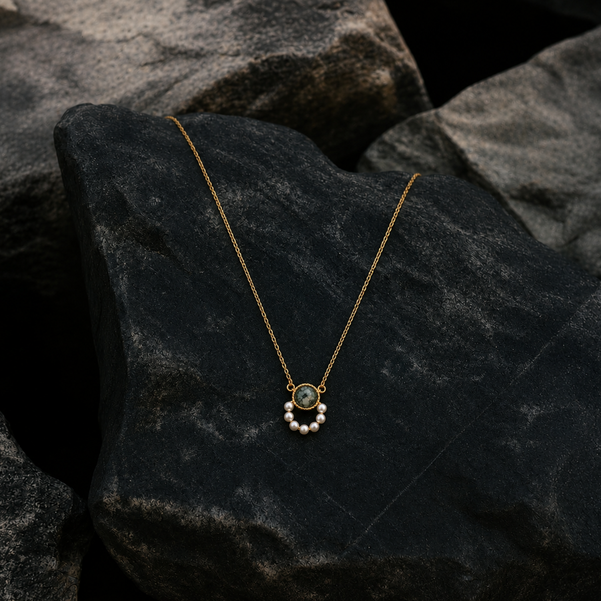 18k gold plated sterling silver pearl moss agate necklace on a rock