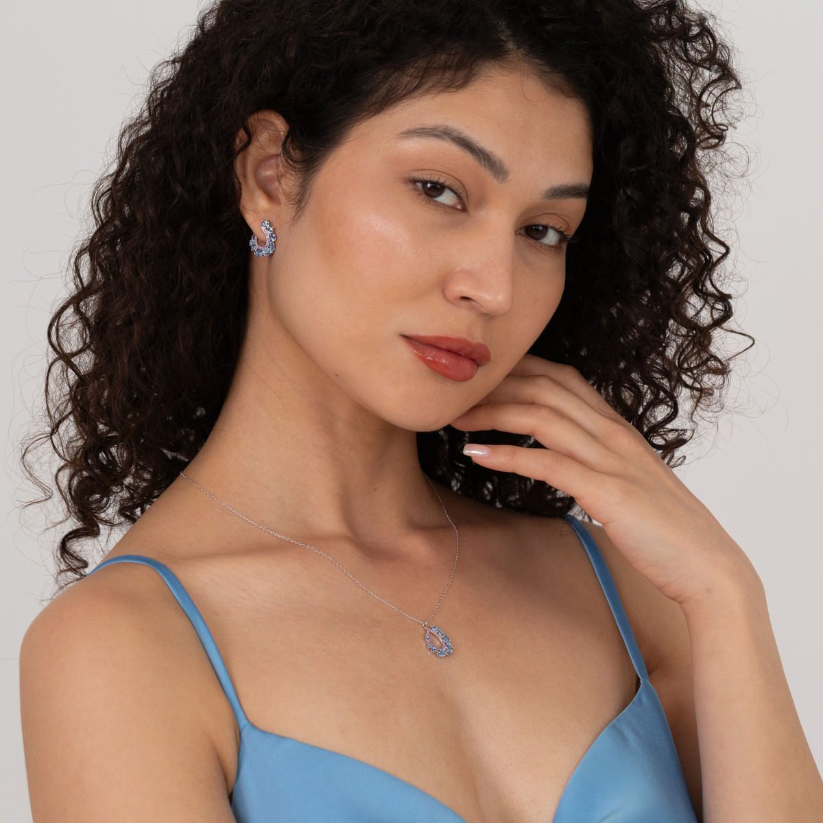 model wearing 925 sterling silver blue and pink cubic zirconia necklace and earrings