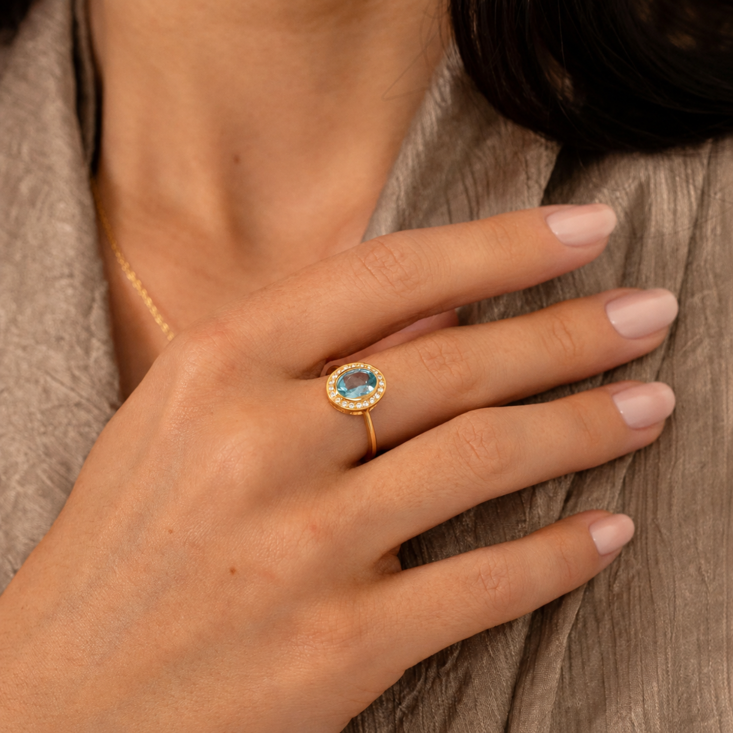 model wearing 18k gold plated sterling silver blue topaz ring cubic zirconia halo