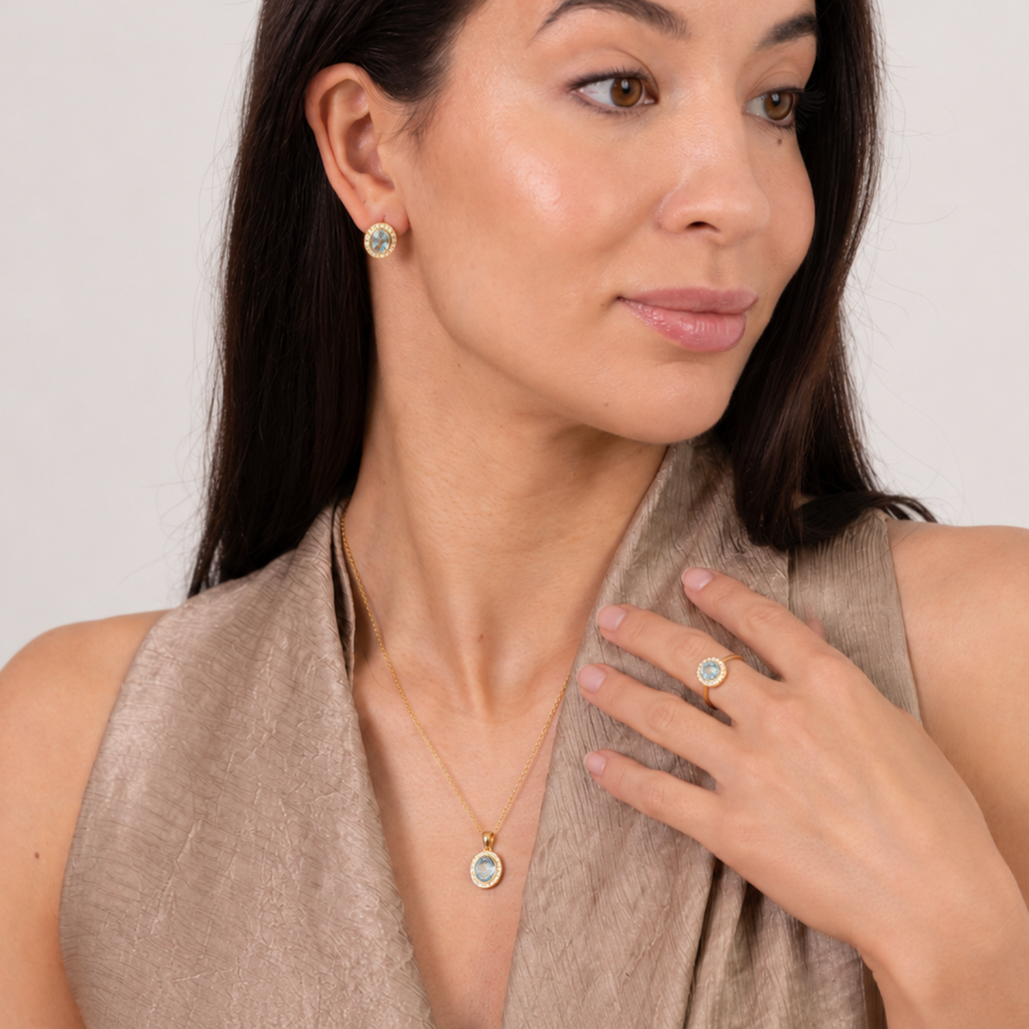 model wearing 18k gold plated sterling silver blue topaz aphrodite jewellery set