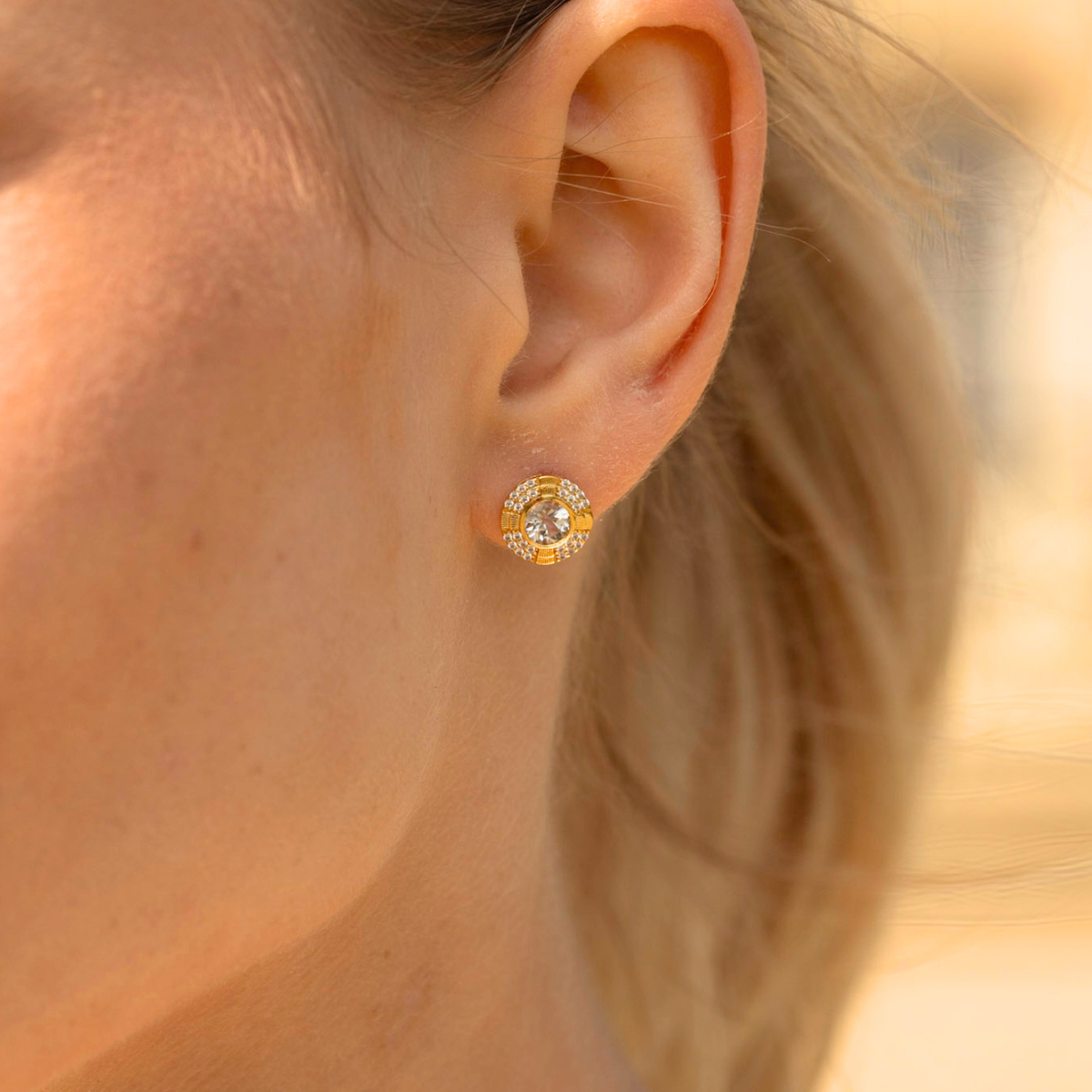 model wearing 18k gold plated sterling silver blue topaz clock earrings