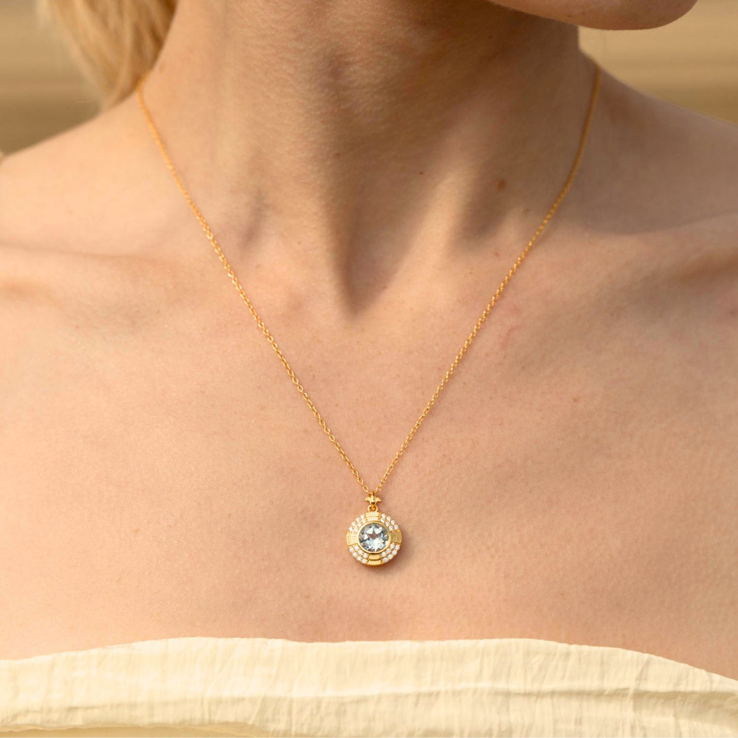 model wearing 18k gold plated sterling silver blue topaz clock necklace