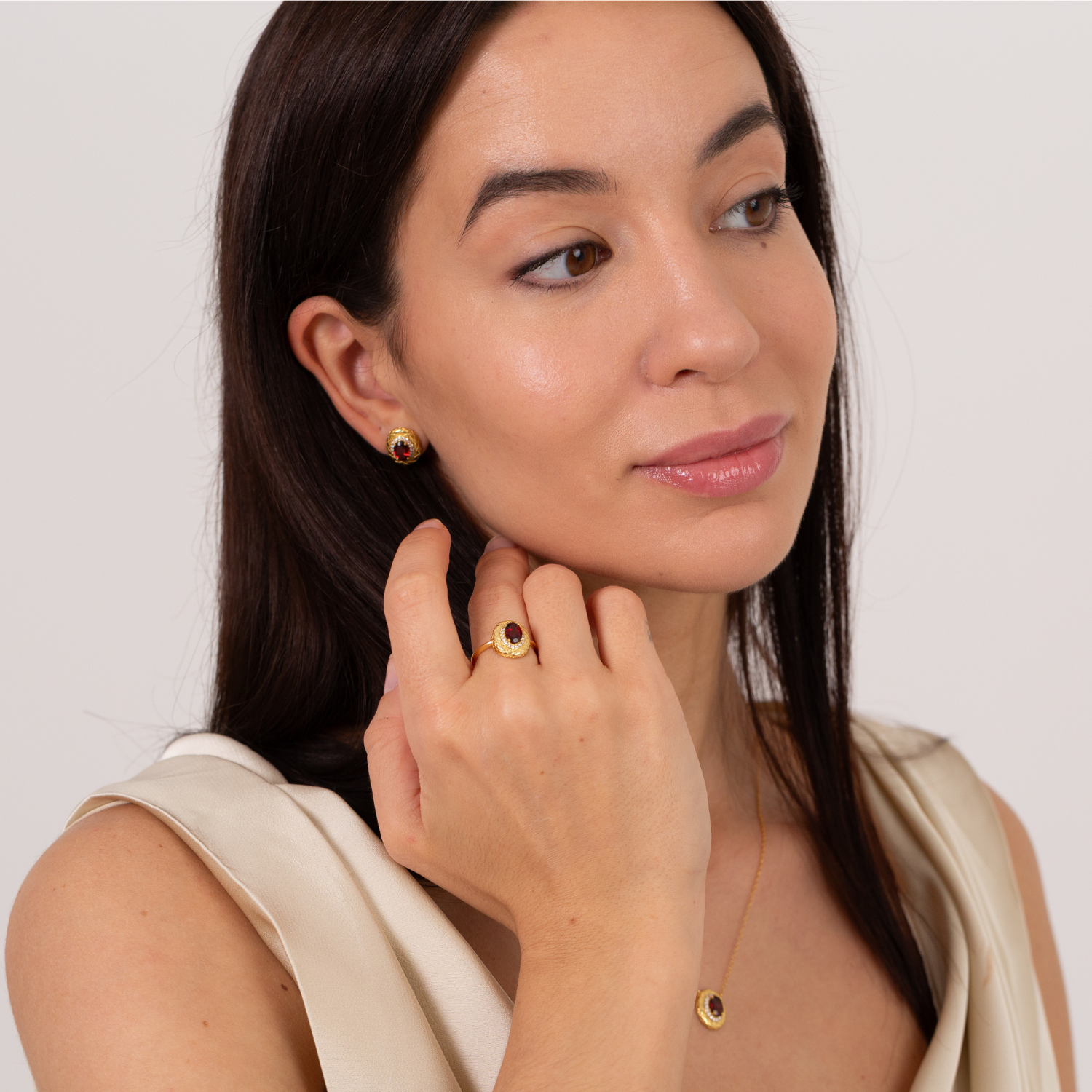 model wearing 18k gold plated sterling silver garnet halo jewellerty set