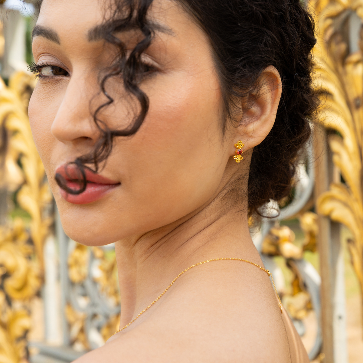 model wearing 18k gold plated sterling silver garnet tijou earrings