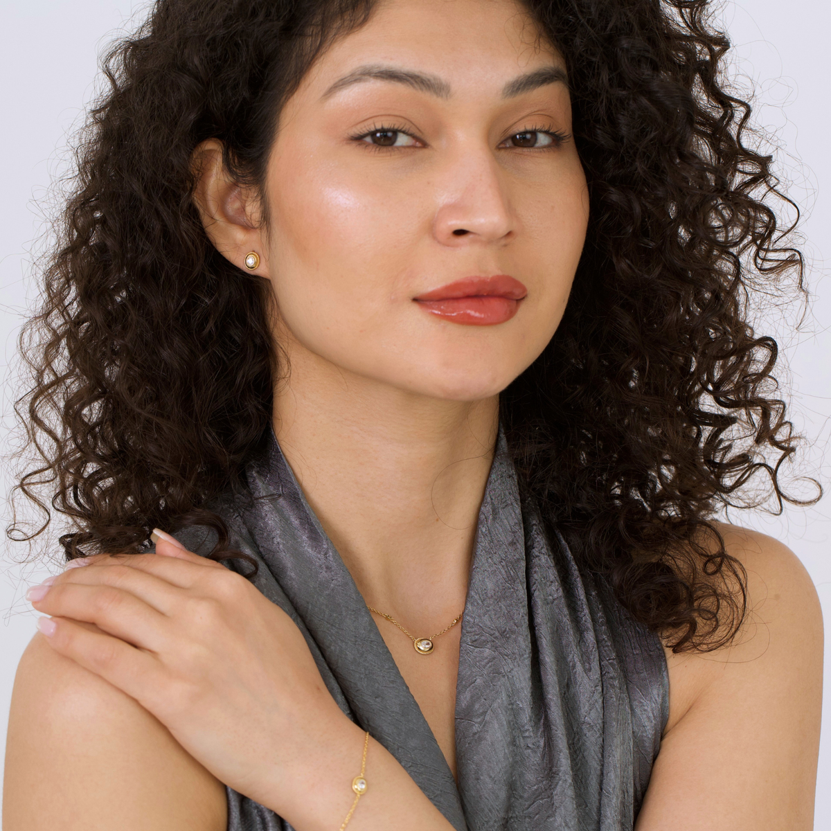 model wearing 18k gold plated sterling silver oval cubic zirconia bracelet and necklace earrings