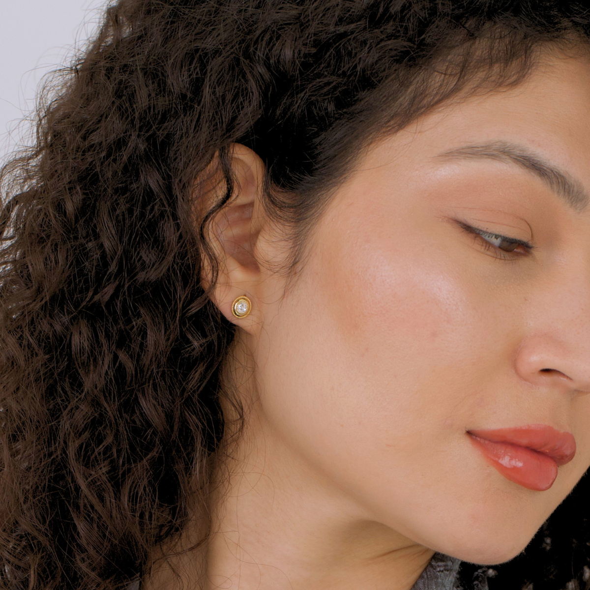 model wearing 18k gold plated sterling silver oval cubic zirconia earrings
