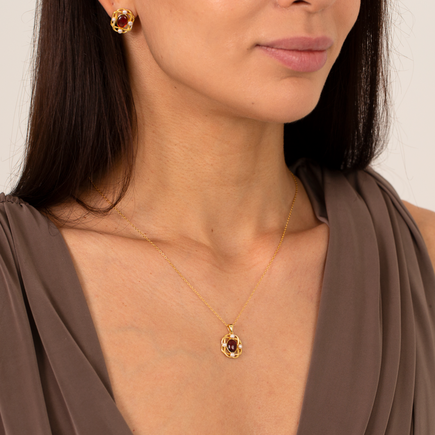 model wearing 18k gold plated sterling silver pearl garnet oval necklace earrings