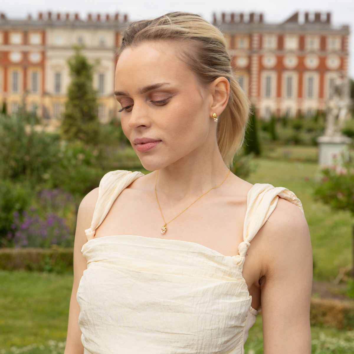 model outside kensington palace wearing 18k gold plated sterling silver pearl wisteria earrings
