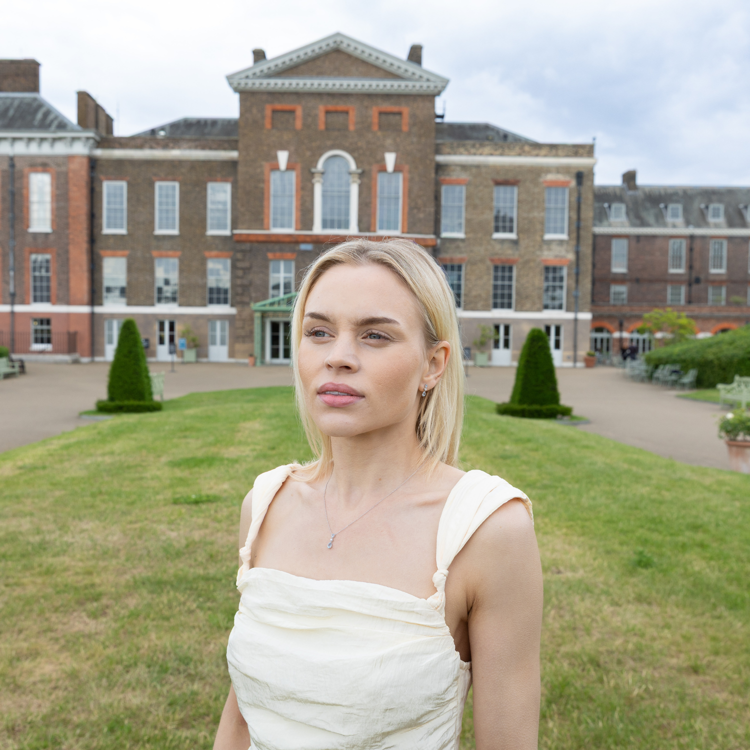 model wearing blue topaz and pearl tiara jewellery set standing outside kensington palace