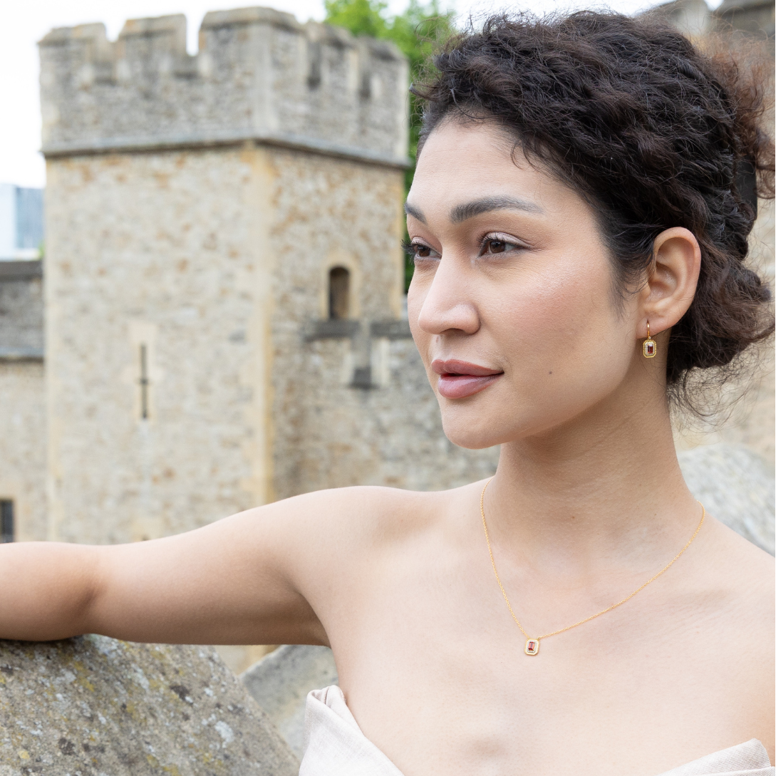 model wearing 18k gold plated sterling silver garnet orb necklace and matching earrings tower of london
