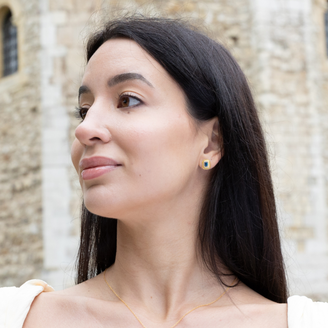 model wearing 18k gold plated sterling silver synthetic sapphire stud earrings