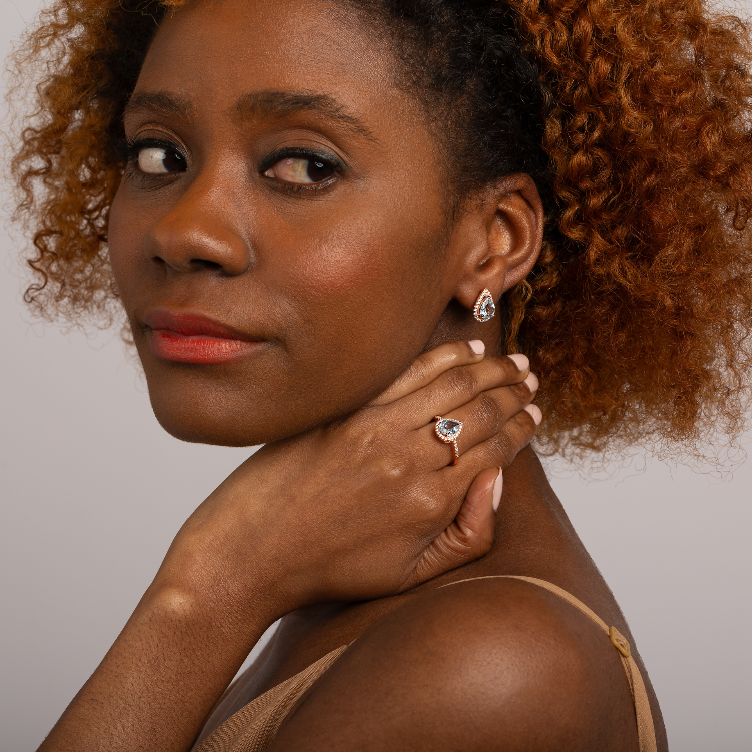 model wearing 18k rose gold plated 925 sterling silver pear drop blue topaz ring